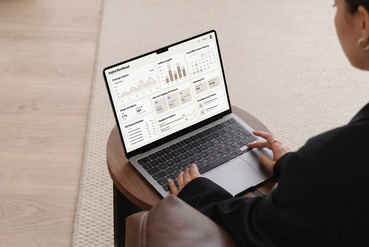 Marketer working on a laptop with campaign analytics and marketing dashboards